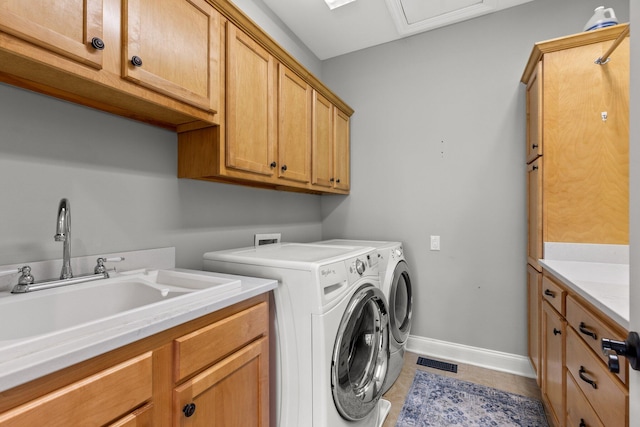 laundry area with baseboards, light tile patterned flooring, cabinet space, a sink, and washer and dryer