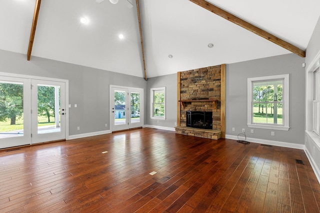 unfurnished living room with beamed ceiling, a fireplace, and baseboards