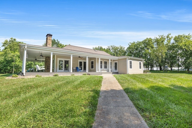 back of house with ceiling fan, french doors, a chimney, a yard, and a patio