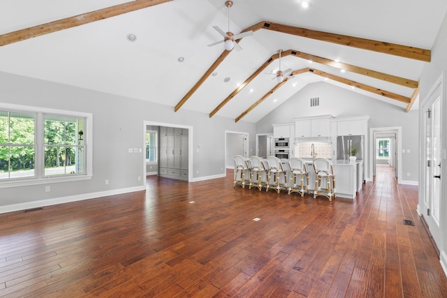 unfurnished living room featuring visible vents, high vaulted ceiling, and dark wood-style flooring