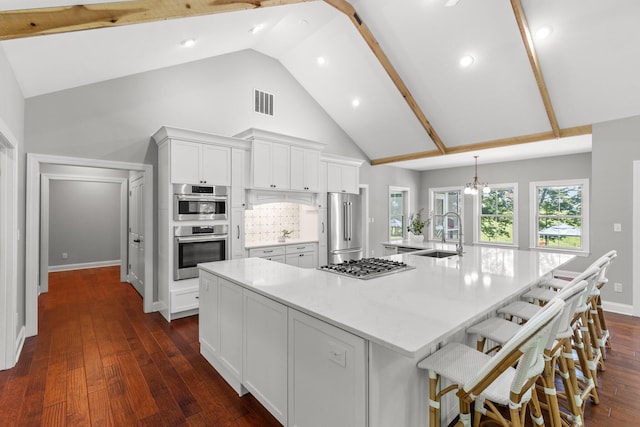 kitchen featuring visible vents, dark wood-type flooring, a large island, white cabinets, and stainless steel appliances