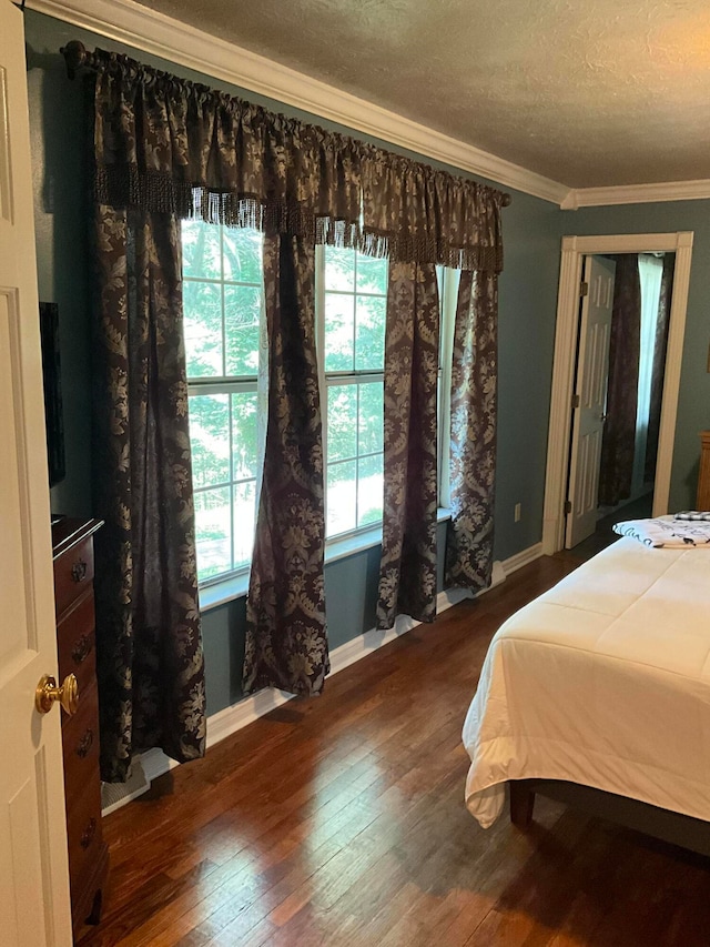 bedroom featuring a textured ceiling, dark hardwood / wood-style flooring, and ornamental molding