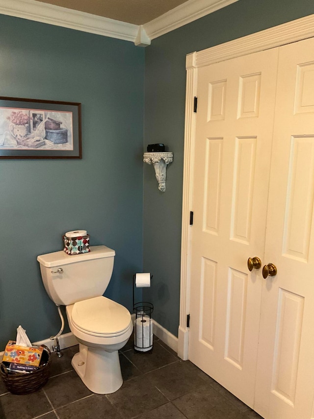 bathroom featuring tile flooring, crown molding, and toilet