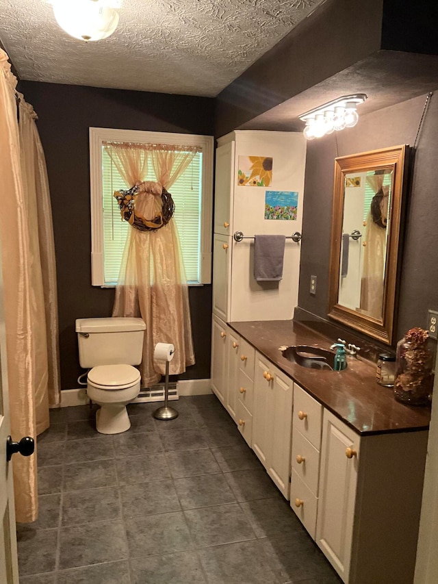 bathroom with toilet, a textured ceiling, tile flooring, and vanity