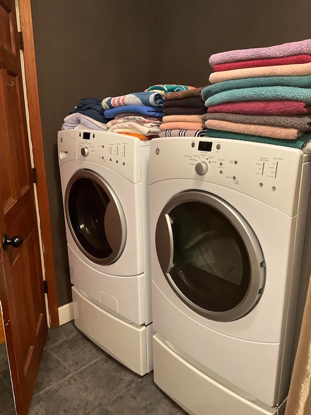 laundry area with washing machine and dryer and dark tile floors