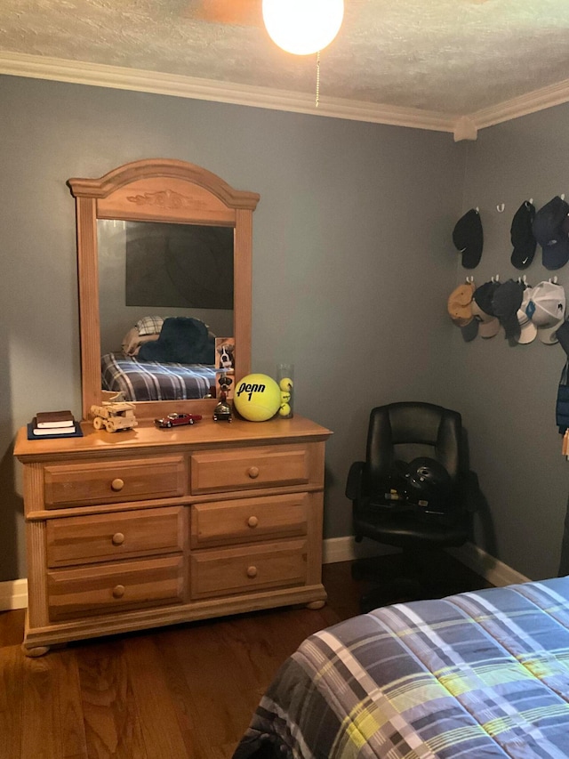 bedroom featuring dark hardwood / wood-style flooring, ornamental molding, and a textured ceiling