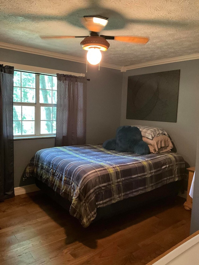 bedroom with ornamental molding, ceiling fan, a textured ceiling, and dark hardwood / wood-style flooring