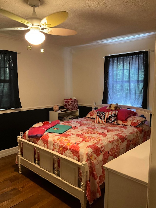 bedroom with a textured ceiling, ceiling fan, and dark hardwood / wood-style floors