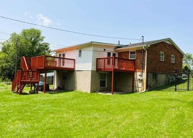 rear view of house with a wooden deck and a yard