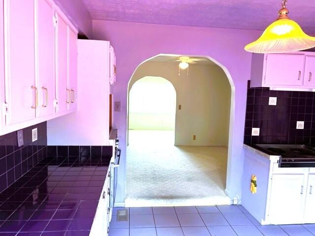 interior space with ceiling fan, tile flooring, and tasteful backsplash