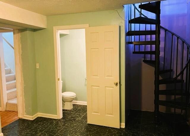 interior space with tile flooring and toilet