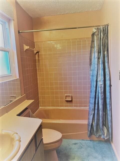 full bathroom featuring shower / bath combination with curtain, toilet, vanity, and a textured ceiling