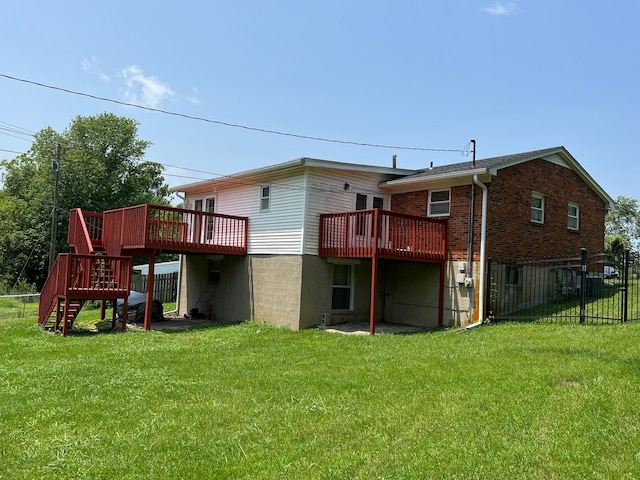 rear view of property featuring a wooden deck and a lawn