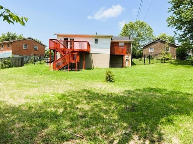 rear view of house with a wooden deck and a lawn