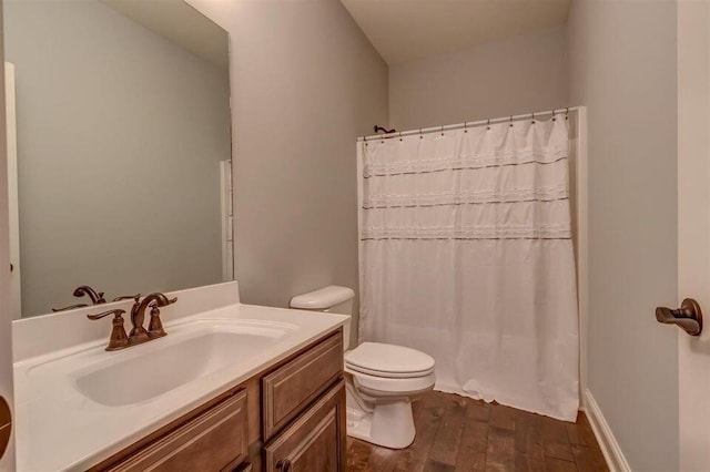 bathroom with toilet, vanity, and wood-type flooring