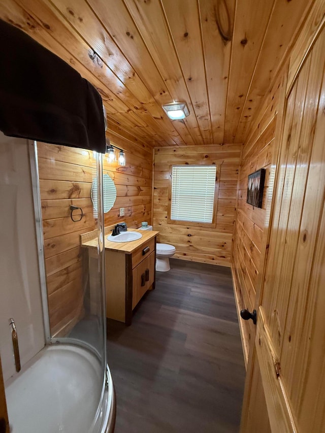 bathroom featuring vanity, wood walls, wood-type flooring, and a shower with shower door