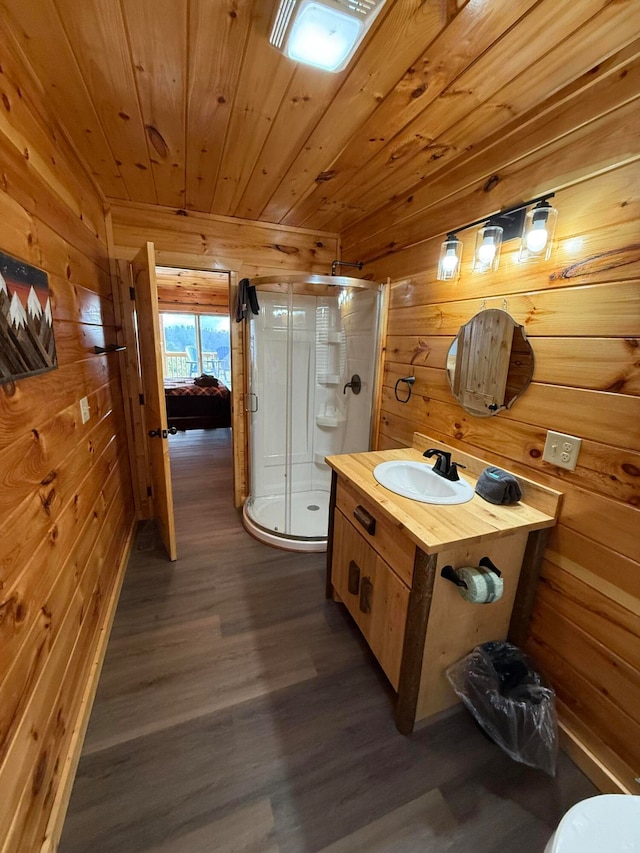 bathroom with wooden walls, vanity, wood-type flooring, and walk in shower