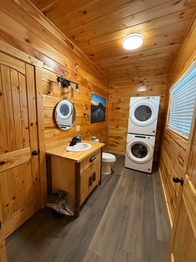 bathroom with hardwood / wood-style floors, toilet, wooden ceiling, and stacked washer / dryer