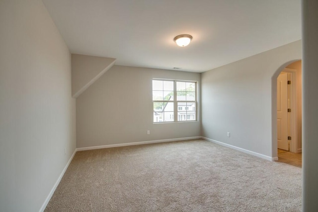 bonus room with lofted ceiling and light carpet