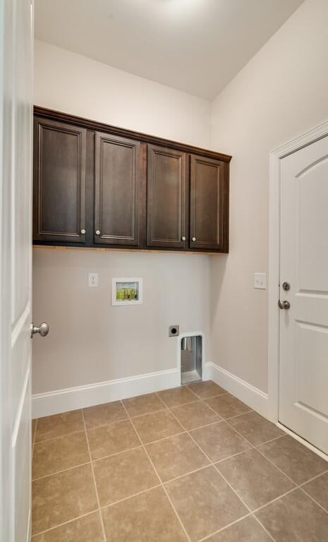 laundry room featuring hookup for an electric dryer, cabinets, light tile floors, and hookup for a washing machine