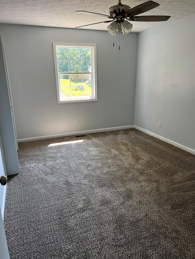 carpeted empty room with a textured ceiling, a ceiling fan, and baseboards