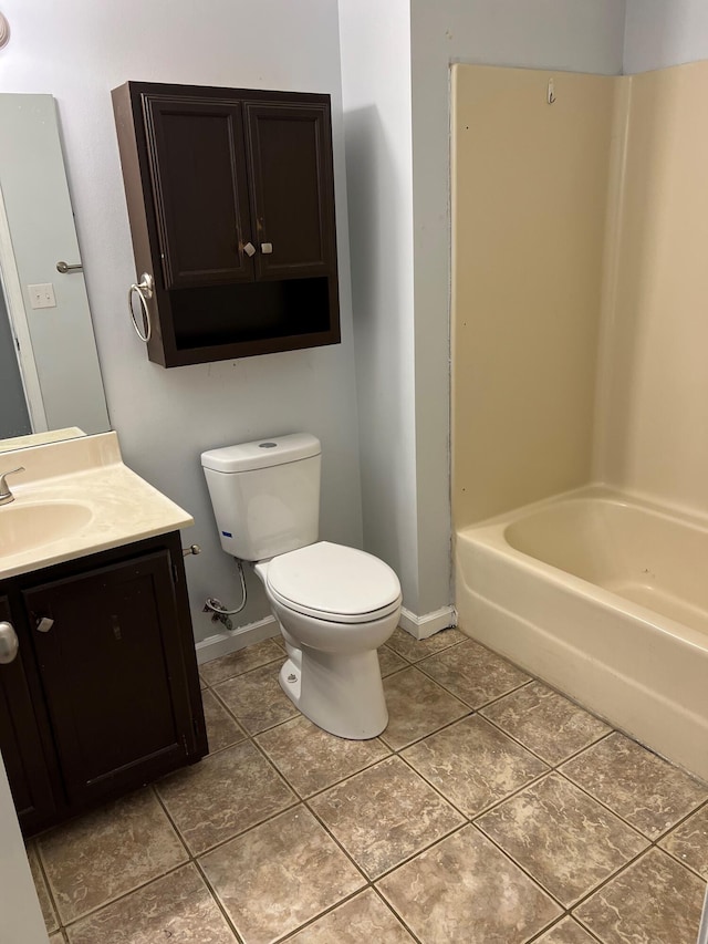 bathroom with baseboards, vanity, toilet, and tile patterned floors