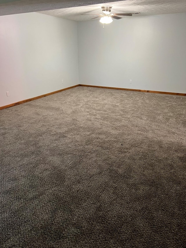 empty room featuring carpet, baseboards, ceiling fan, and a textured ceiling