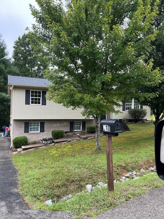 view of front facade with brick siding and a front yard