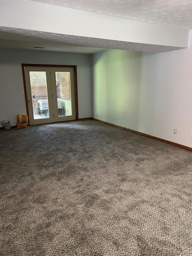 carpeted spare room with baseboards and a textured ceiling