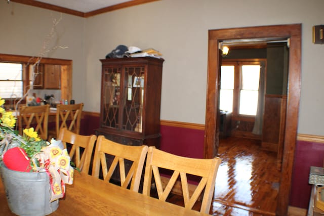 dining space featuring crown molding, a wealth of natural light, and dark hardwood / wood-style floors