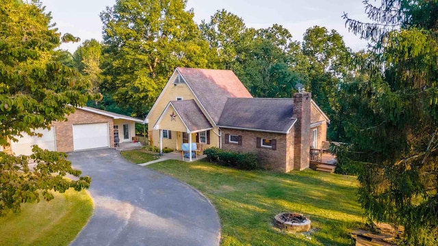 view of front of home featuring a front lawn, a garage, and a fire pit