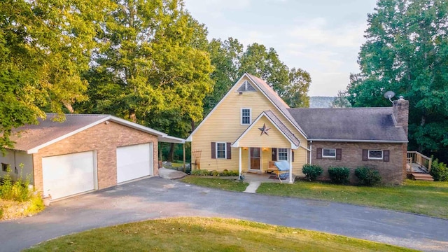 view of front of home with covered porch, a front lawn, and a garage