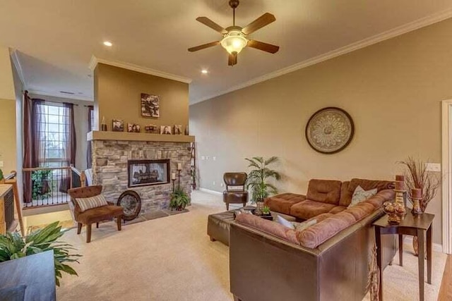 carpeted living room with ceiling fan, crown molding, and a stone fireplace