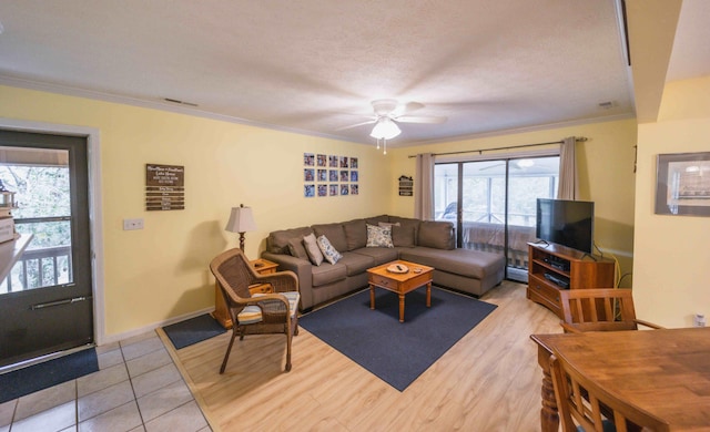 living room with ceiling fan, crown molding, light hardwood / wood-style flooring, and a textured ceiling