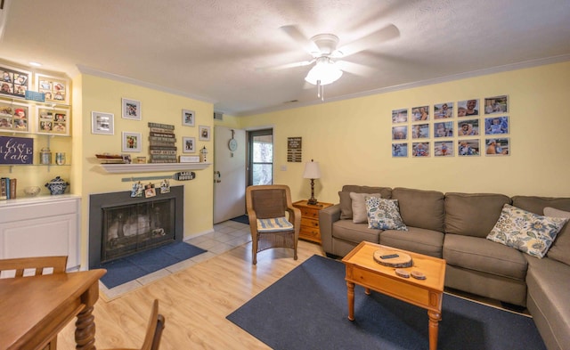 living room featuring ornamental molding, ceiling fan, and light wood-type flooring