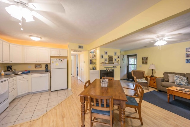 dining room with ceiling fan, light tile floors, and sink