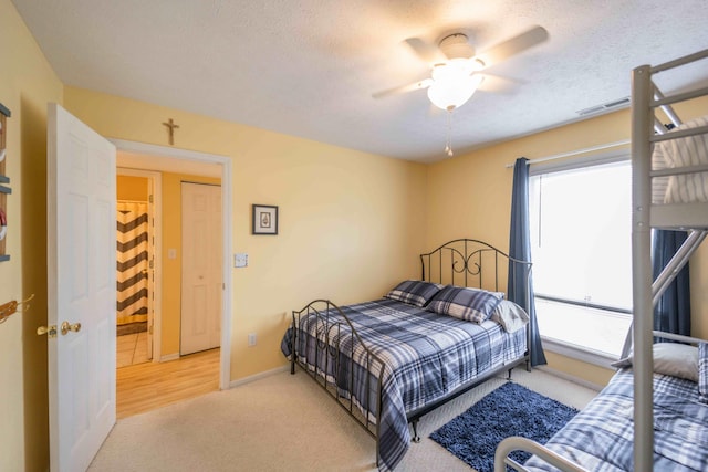 carpeted bedroom with ceiling fan and a textured ceiling