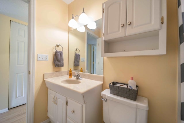 bathroom featuring large vanity, toilet, and hardwood / wood-style flooring