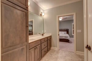 bathroom featuring crown molding, double sink vanity, and tile flooring