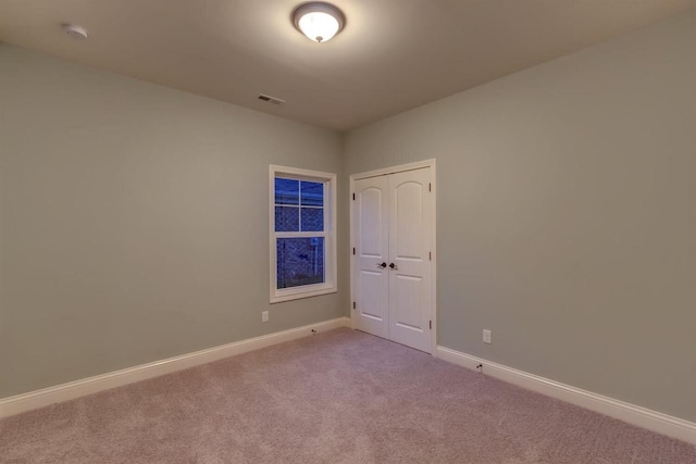 unfurnished room featuring light colored carpet