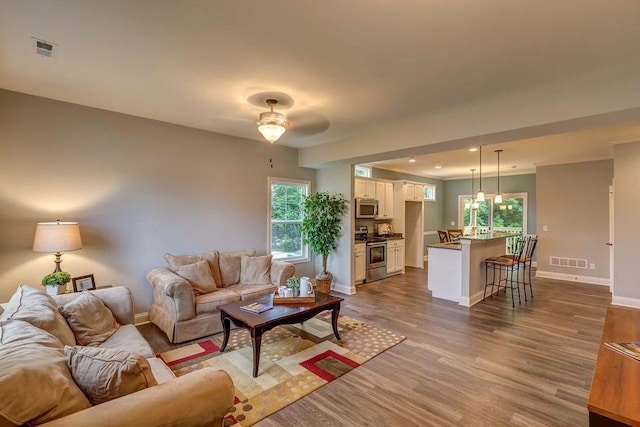 living room with light hardwood / wood-style flooring and ceiling fan