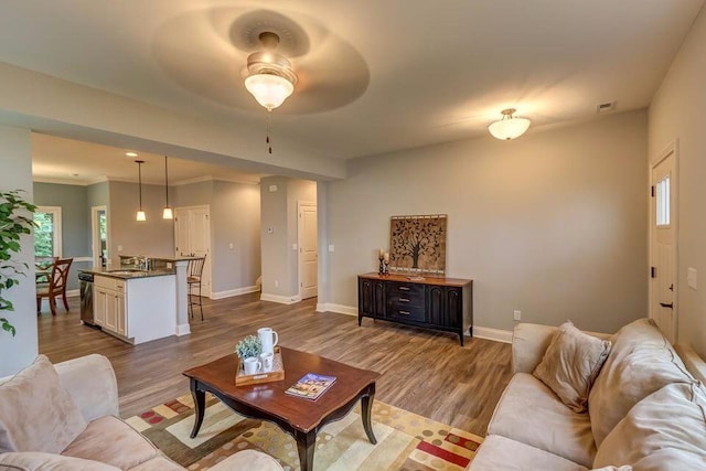 living room featuring visible vents, baseboards, dark wood finished floors, and crown molding