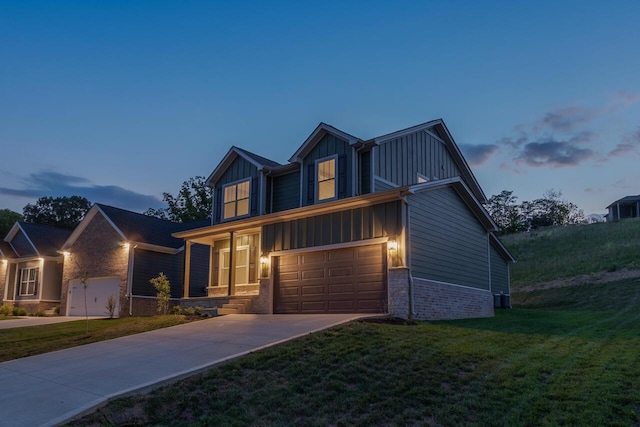 view of front facade with a garage, concrete driveway, a front yard, board and batten siding, and brick siding