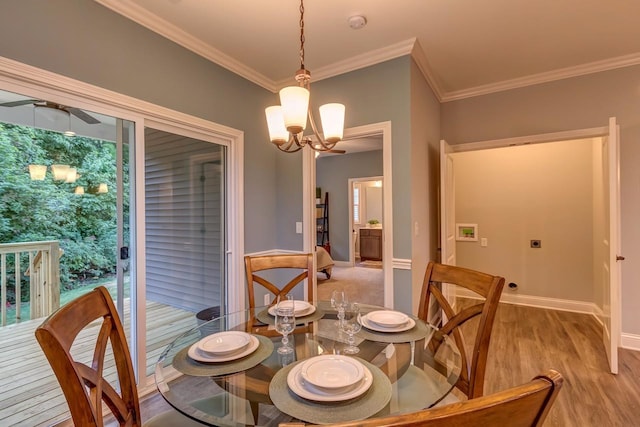 dining space featuring light hardwood / wood-style flooring, an inviting chandelier, ornamental molding, and a wealth of natural light