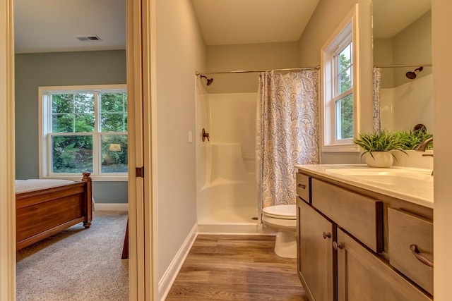 bathroom with curtained shower, vanity, toilet, and hardwood / wood-style floors