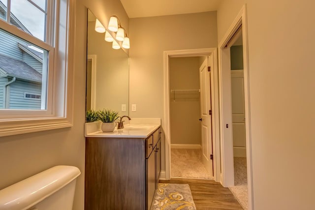 bathroom with oversized vanity, toilet, and wood-type flooring