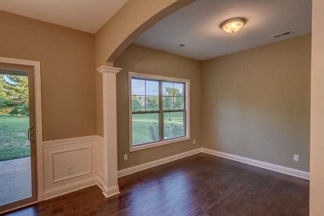 interior space with ornate columns and dark hardwood / wood-style floors