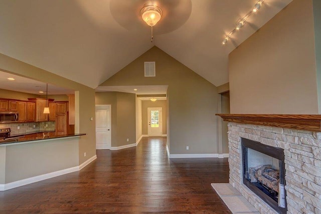 unfurnished living room featuring a fireplace, ceiling fan, high vaulted ceiling, dark wood-type flooring, and track lighting