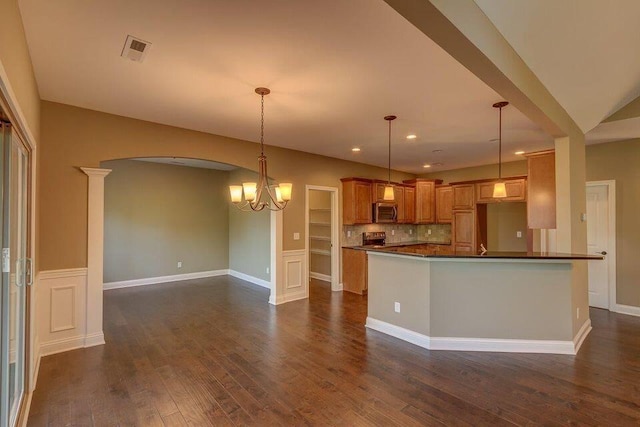 kitchen featuring stove, an inviting chandelier, decorative light fixtures, decorative backsplash, and dark wood-type flooring