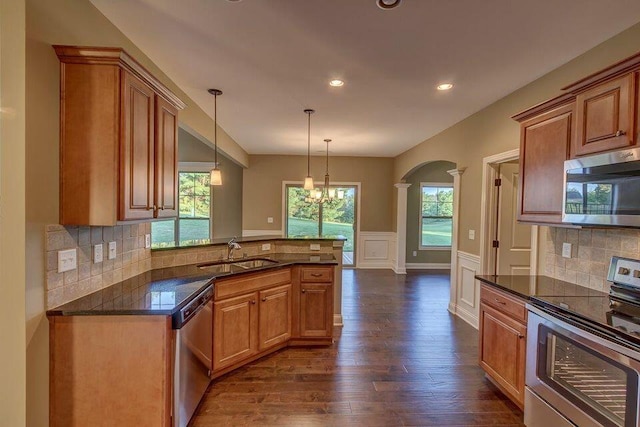 kitchen featuring appliances with stainless steel finishes, dark hardwood / wood-style flooring, backsplash, and sink